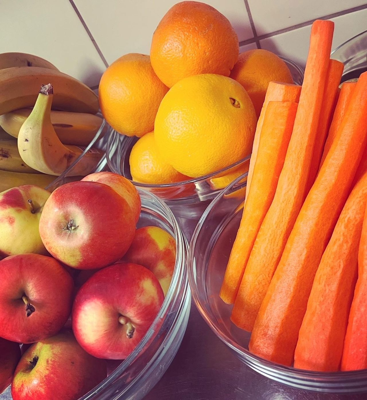 Frukt i kantina, epler, banan, appelsin og gulrot